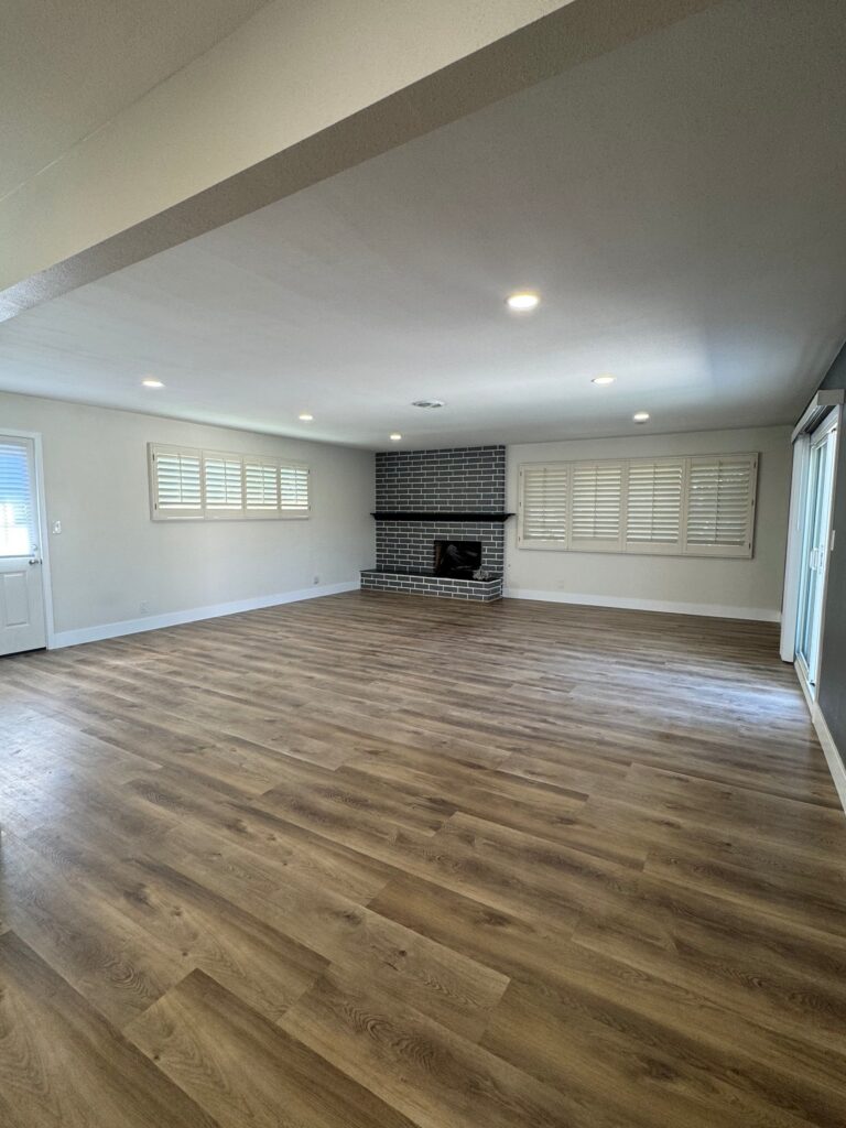 Living room with brick fireplace and new flooring, Anaheim, CA
